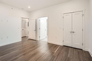 Unfurnished bedroom featuring dark wood-type floo
