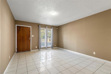 Unfurnished room featuring light tile patterned f
