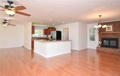 Open floor plan with hardwood floors, ceiling fans