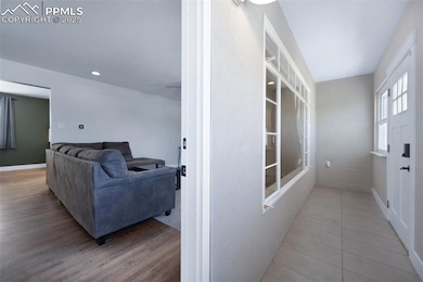Corridor with tile patterned floors, baseboards, a