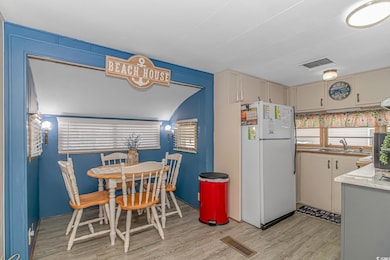Kitchen featuring light hardwood / wood-style flooring, sink, and white refrigerator