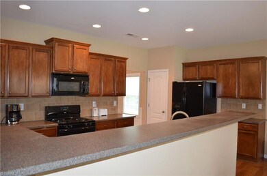 Kitchen with breakfast bar and granite counter. Notice the recessed lighting.