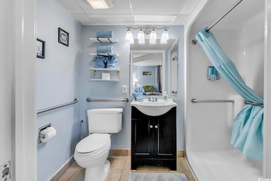 Bathroom with a paneled ceiling, tile patterned fl