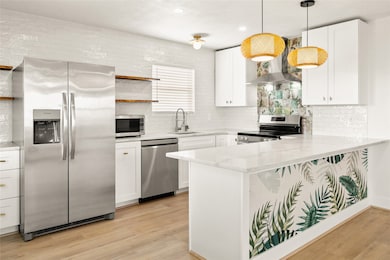 This stylish kitchen is open to the living area, drink fridge, stainless appliance, open wood shelves with live edge, and seating at the bar for 4.