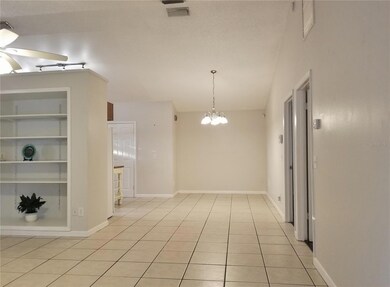 View from the back door, towards the Great Room (to left) with built-in shelving, and Dining Rm or Office space (ahead). Bedrooms to the RIGHT. Kitchen to the left of the Dining Area. GREAT TILE FLOORING and VOLUME CEILINGS!