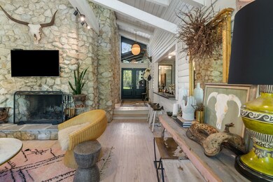 The great room’s stone fireplace anchors the space with rustic elegance.