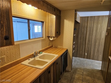 Kitchen featuring light countertops, wallpapered w