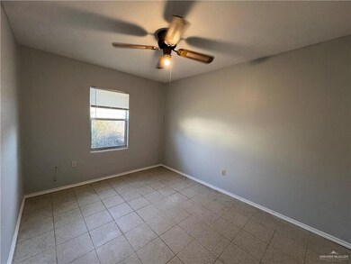 Empty room with ceiling fan and tile patterned floors