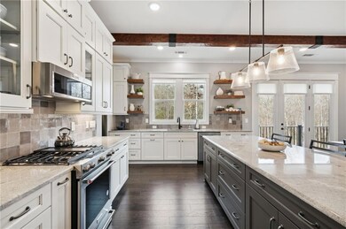 Kitchen with white cabinets, beamed ceiling, appli