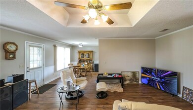 Living area with visible vents, a ceiling fan, a t
