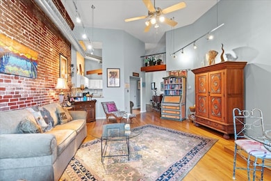Living room featuring ceiling fan, high vaulted ce