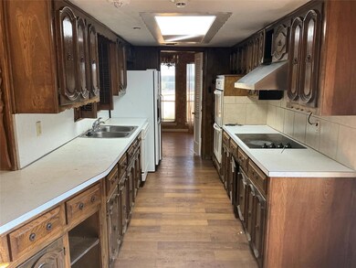 Kitchen featuring sink, range hood, hardwood / woo