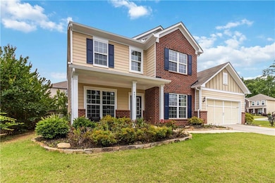 Traditional home featuring brick siding, driveway, a garage, and a front lawn