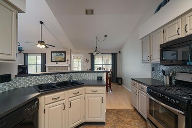 Kitchen with vaulted ceiling, a sink, dark counte