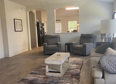 Living area featuring arched walkways, wood finis