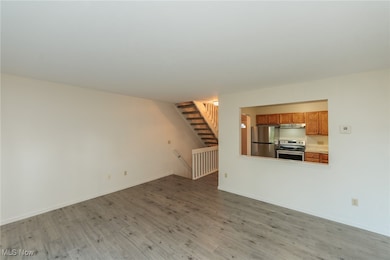 Unfurnished living room with wood finished floors and stairs