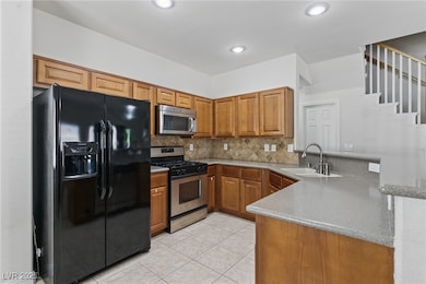 Kitchen featuring brown cabinets, a peninsula, app