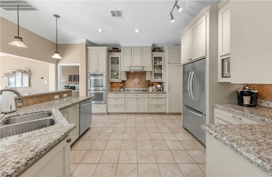 Kitchen with visible vents, a sink, stainless stee