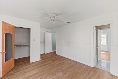Unfurnished bedroom featuring visible vents, wood