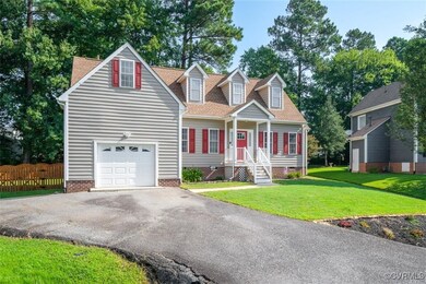 Cape cod-style house with a garage and a front law