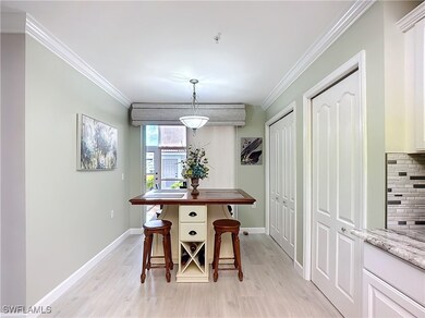 Dining space with crown molding and light hardwood