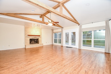 Step inside to discover a meticulously designed space boasting high living room ceilings with dramatic exposed wood beams.