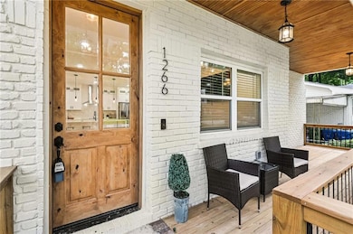 Doorway to property with brick siding and a wooden deck