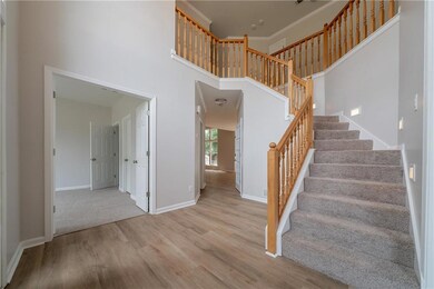Staircase featuring wood finished floors, a high ceiling, and baseboards