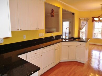 Kitchen with beautiful hardwoods, high upper cabinets, black granite countertops, and open to the Breakfast Rm.