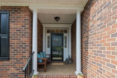 Quaint front porch is covered and offers pretty ar