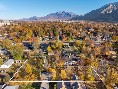 Aerial perspective of suburban area featuring a mountain backdrop and property boundaries highlighted