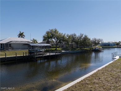 Dock area with a water view and a yard