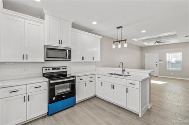Kitchen featuring stainless steel appliances, ceiling fan, backsplash, and kitchen peninsula