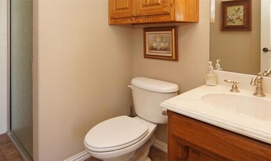 Bathroom featuring an enclosed shower, toilet, tile flooring, and vanity