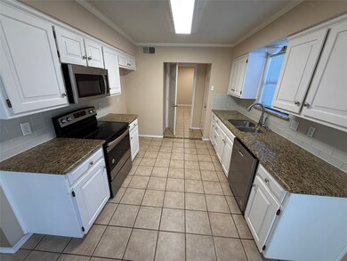 Kitchen featuring tasteful backsplash, stainless steel appliances, white cabinetry, light tile patterned flooring, and ornamental molding