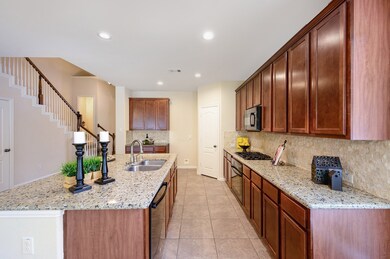 The fabulous kitchen boasts granite countertops, large island, black appliances, a corner pantry and 42