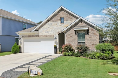 View of front of house featuring concrete driveway, a front lawn, a garage, brick siding, and roof with shingles