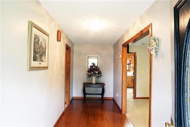 The grand entry foyer has wood flooring and plenty of wall space.