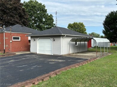 Garage featuring a carport and a lawn