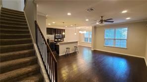 Unfurnished living room featuring a ceiling fan, 