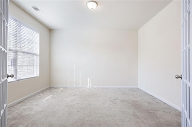 Carpeted empty room with baseboards