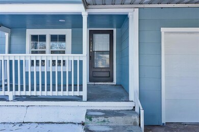 Doorway to property with covered porch and a garag