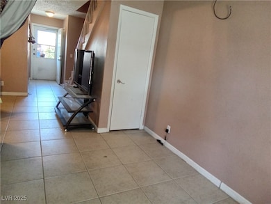 Hallway featuring light tile patterned floors, bas