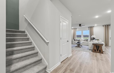 Stairway with a ceiling fan, baseboards, recessed 