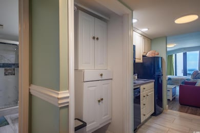 Kitchen featuring light wood-style flooring, black appliances, white cabinets, and recessed lighting