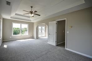 Carpeted spare room with ceiling fan and a raised 