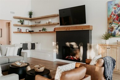 Living area with wood finished floors and a glass covered fireplace