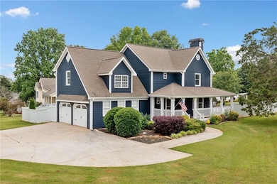 View of front of property featuring covered porch, concrete driveway, a garage, a chimney, and roof with shingles