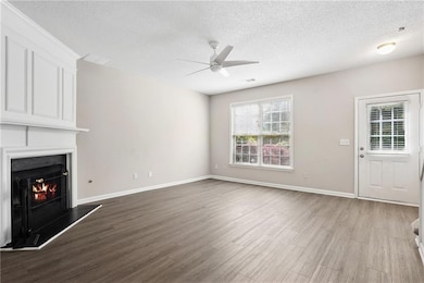 Unfurnished living room featuring a ceiling fan, w