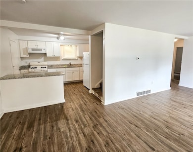 Open-concept living and dining area with wooden fl
